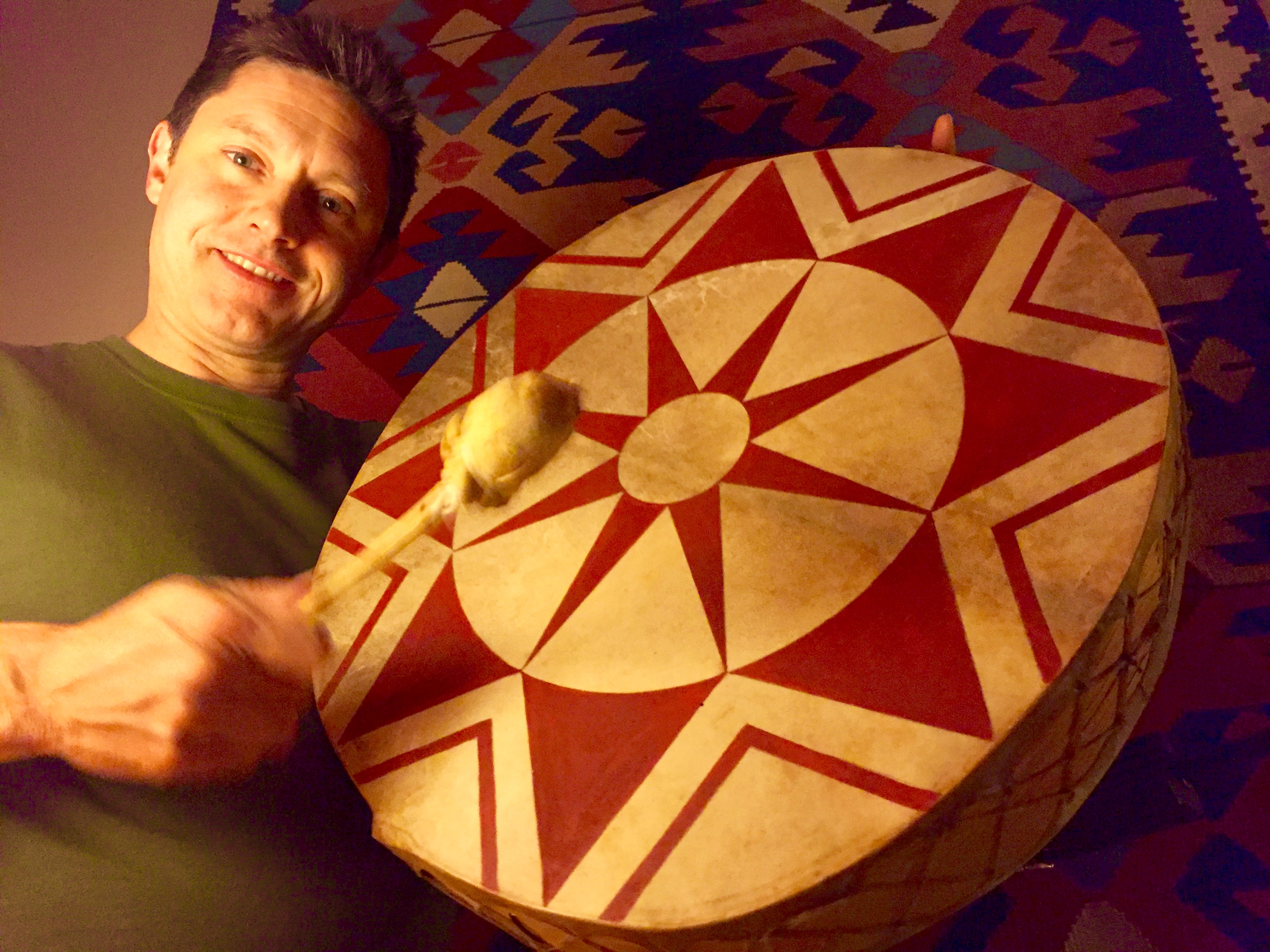 A portrait of a man playing a hand drum