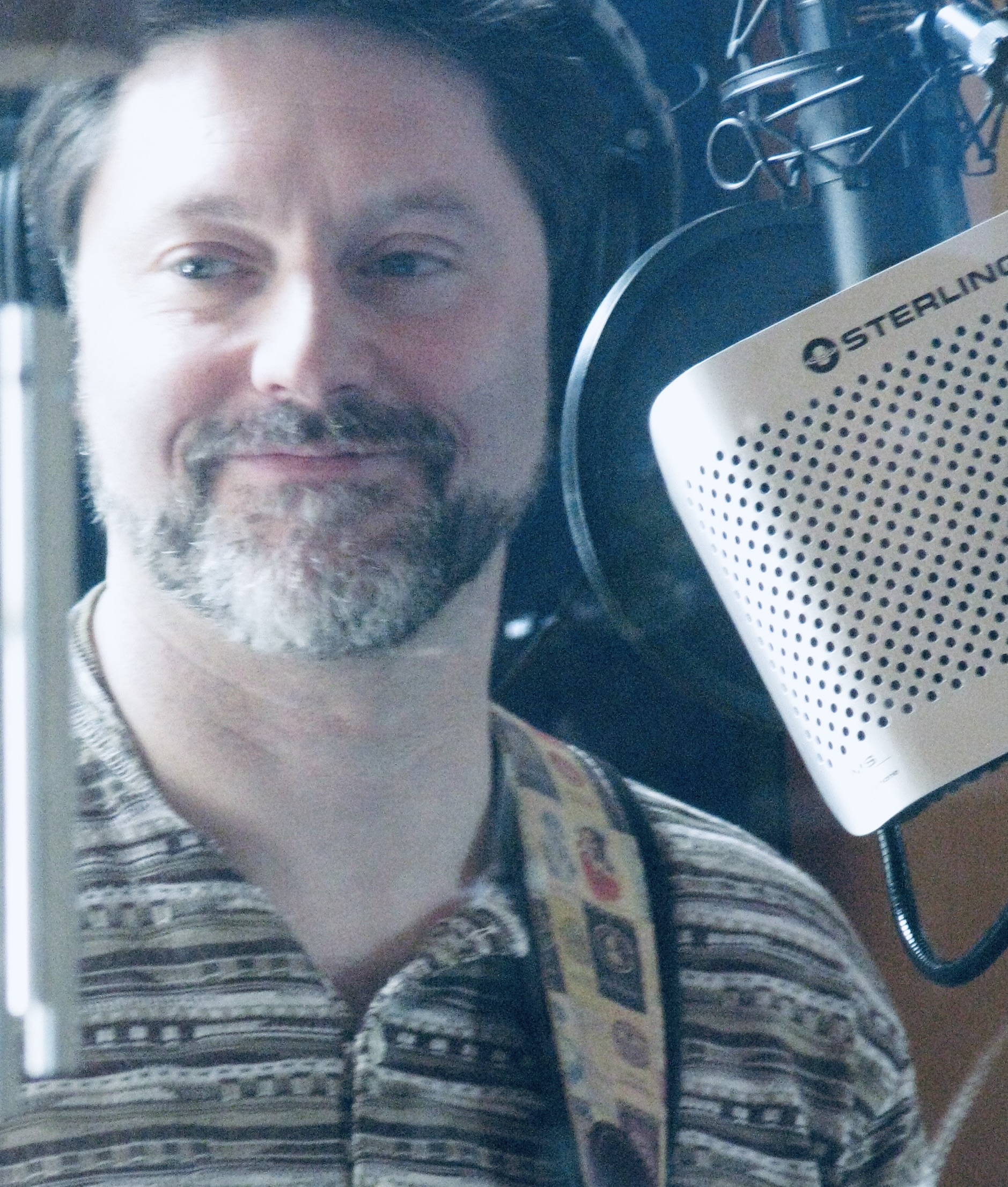 A close-up portrait taken during a podcast recording
